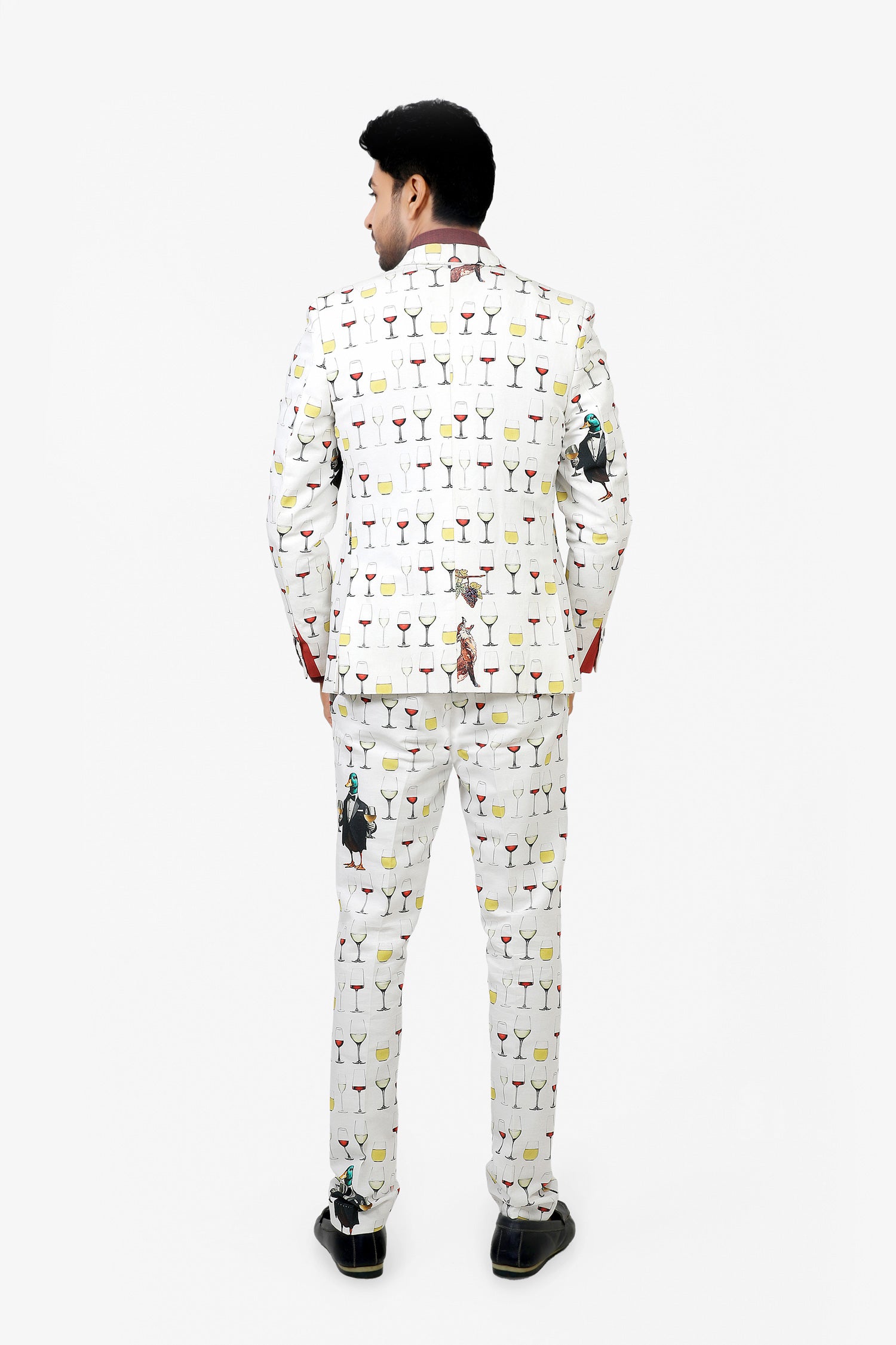 Man wearing a white suit with colorful cocktail-themed pattern on a white background