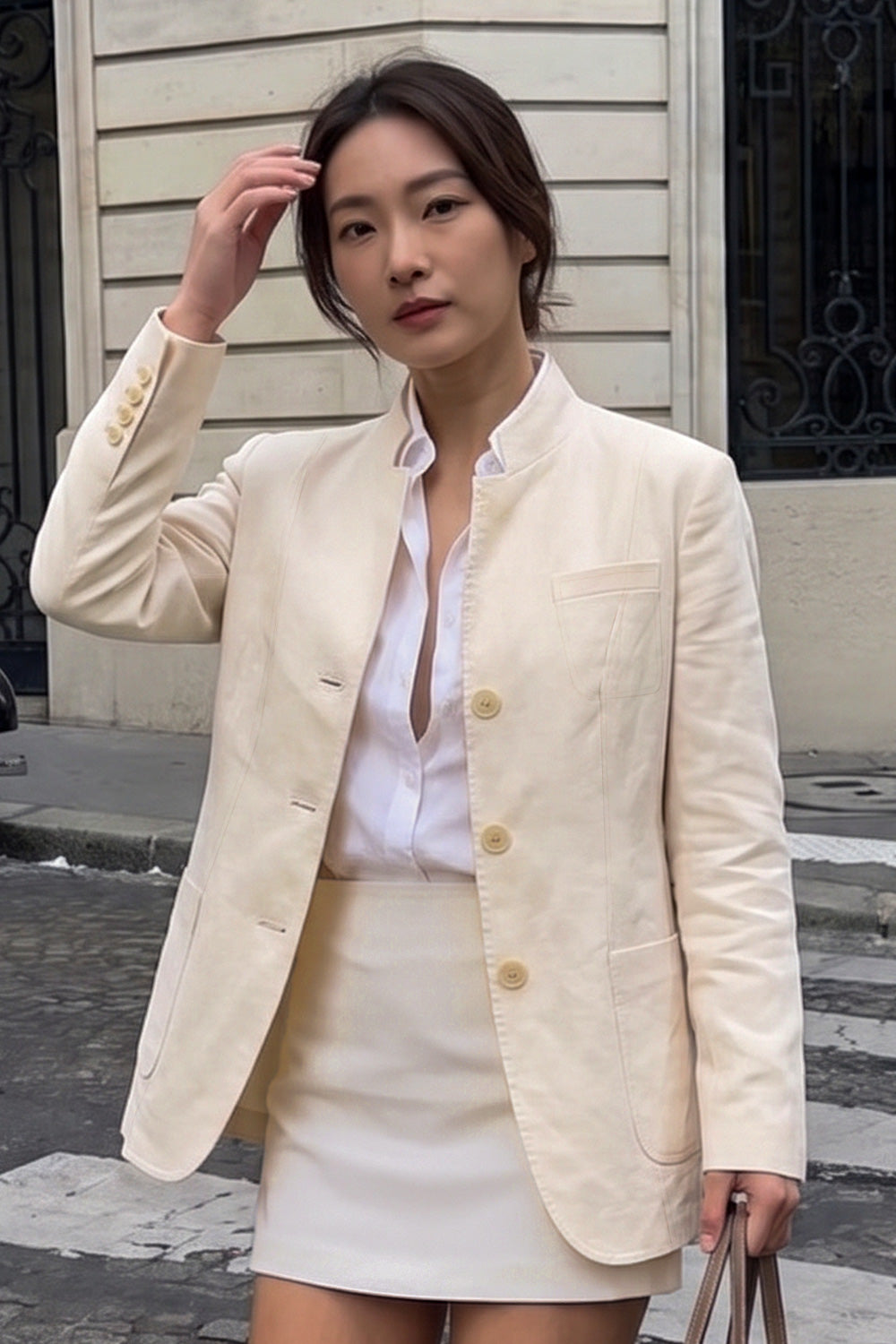 Woman wearing the Assam Muga silk jacket open over a white shirt with a cream mini skirt
