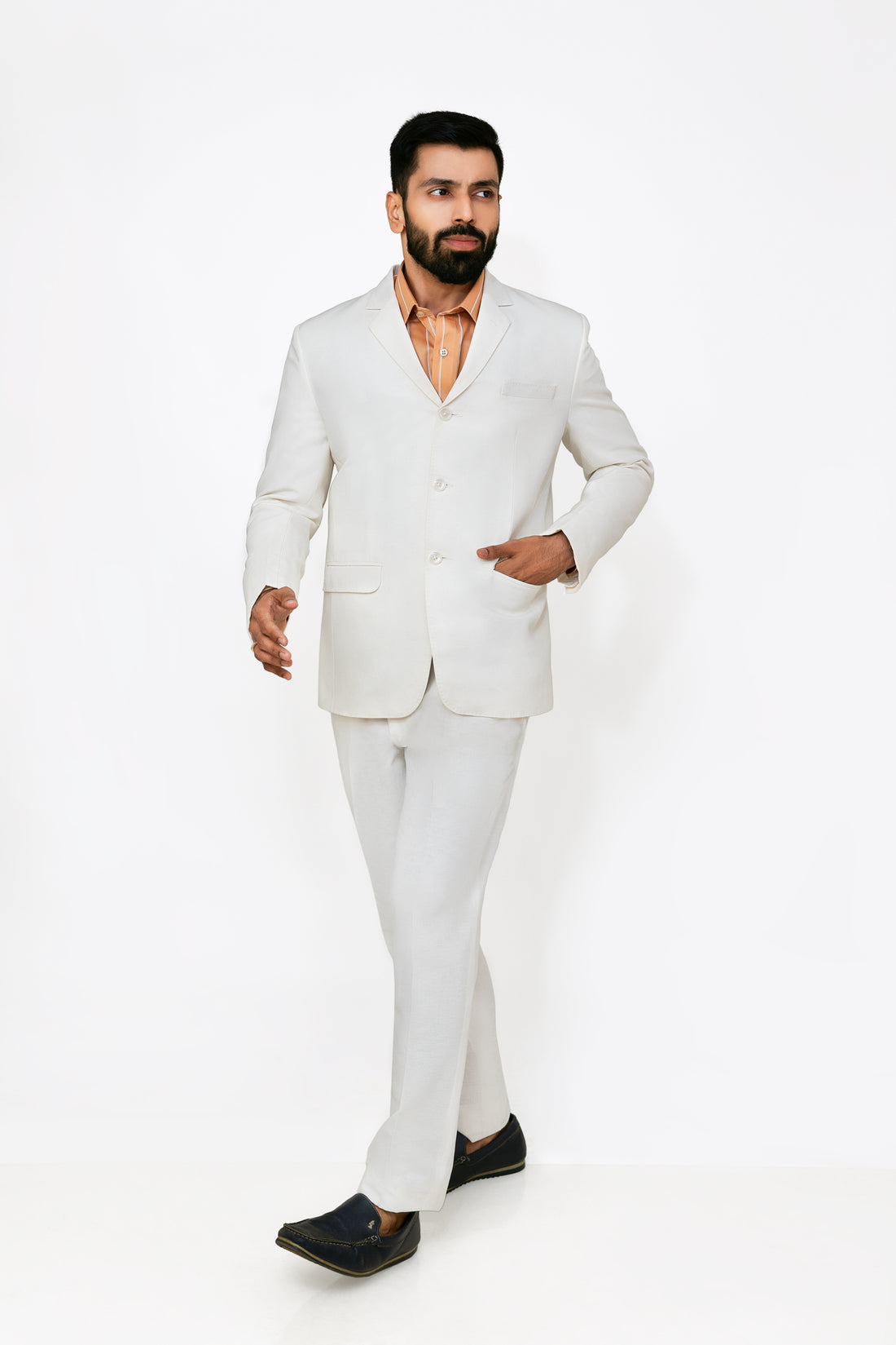 A male model wearing a white hemp blazer with a notch lapel, three buttons, two flap pockets and a chest pocket. The blazer is fully lined with a cotton satin interior.