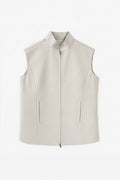 A sleeveless zip-front linen vest in a light warm gray or oatmeal tone, shown flat against a plain white background.