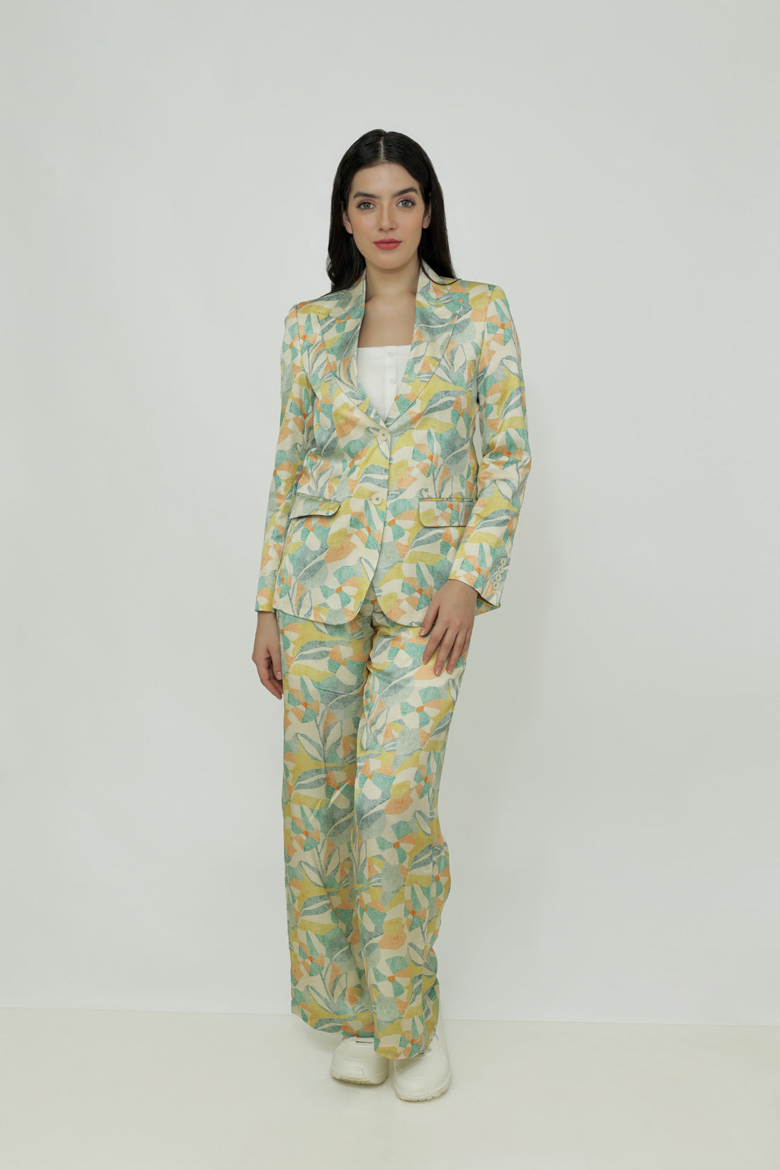 A female model wearing a floral print silk blazer with notch lapel, single-breasted with two buttons, and functional sleeves with four buttons.