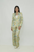 A female model wearing a floral print silk blazer with notch lapel, single-breasted with two buttons, and functional sleeves with four buttons.