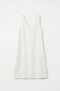 A sleeveless white V-neck hemp dress with a relaxed, slightly loose fit, laid flat against a clean white background.