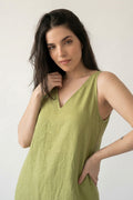 A woman modeling a sleeveless olive green V-neck hemp dress against a plain off-white background.