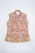 A sleeveless collared  linen vest with a front zipper, featuring an intricate multicolor patchwork print with red, blue, yellow, and brown motifs on a light beige background, shown flat against a white background.