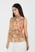 Woman wearing a sleeveless, patterned top with a plain background