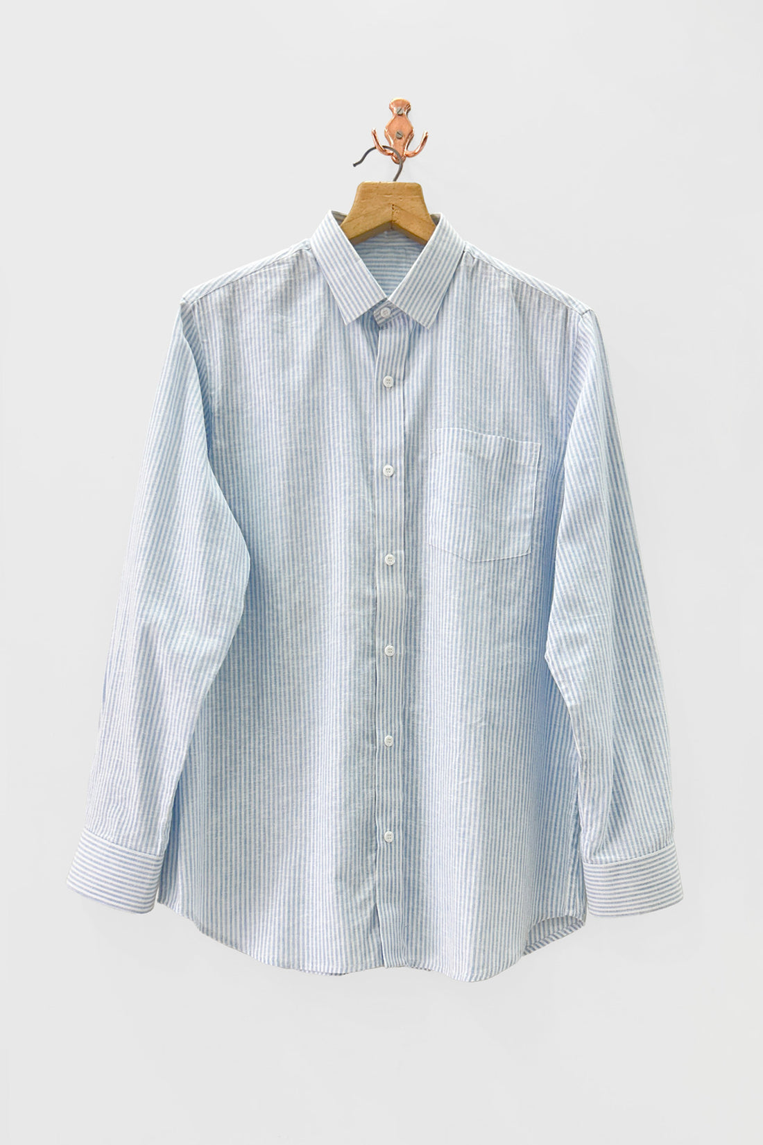 Light blue and white striped shirt on a hanger against a light gray background