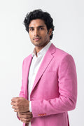 A man wearing a bright pink hemp blazer over a white dress shirt, standing against a plain white studio background.