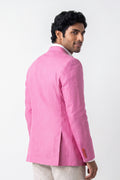 A man wearing a bright pink hemp blazer jacket, shown from a three-quarters back view against a plain white studio background.
