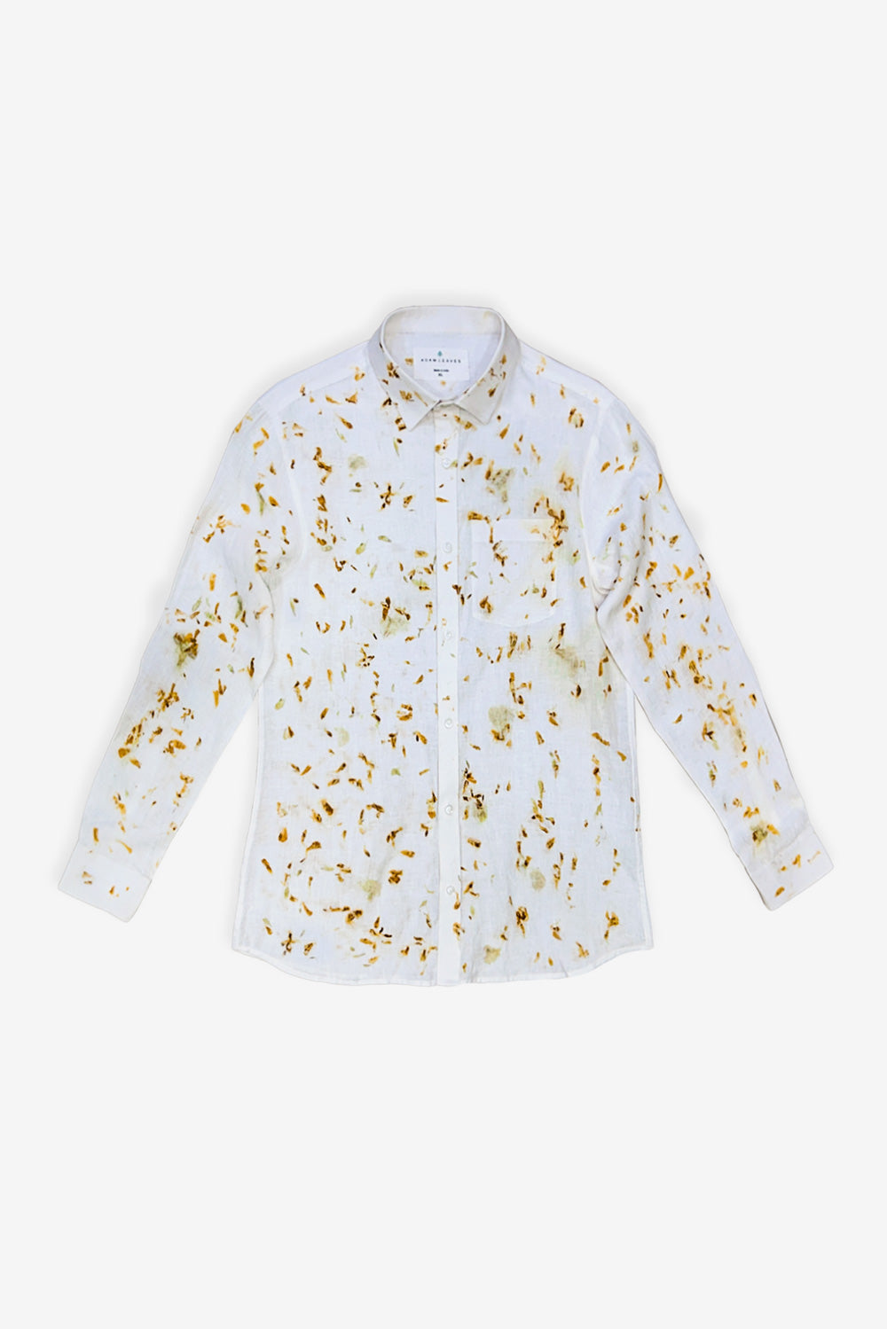 A man modeling a white long-sleeve button-up shirt with a delicate gold floral pattern, paired with white trousers and white sneakers, against a plain white studio background.
