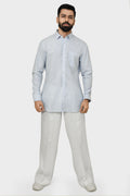 Man wearing a light blue kurta and pants on a white background
