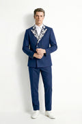 Man wearing a blue suit with a patterned shirt against a white background
