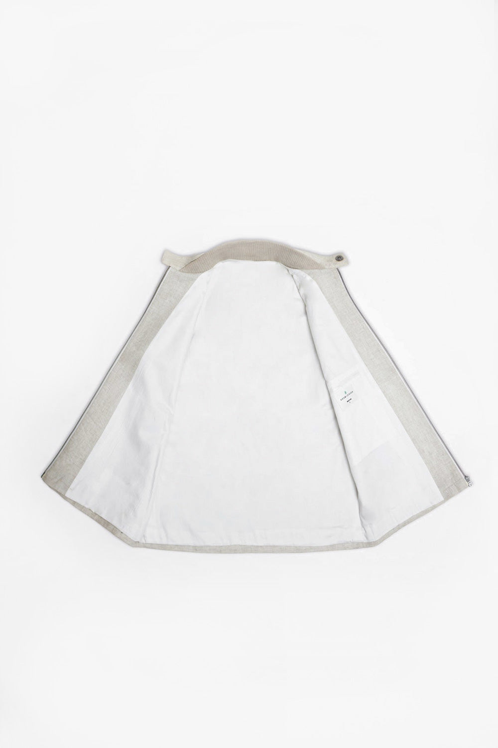 A iterior of the tailored made linen vest  with light gray trim and a strap at the collar, laid flat on a white background.