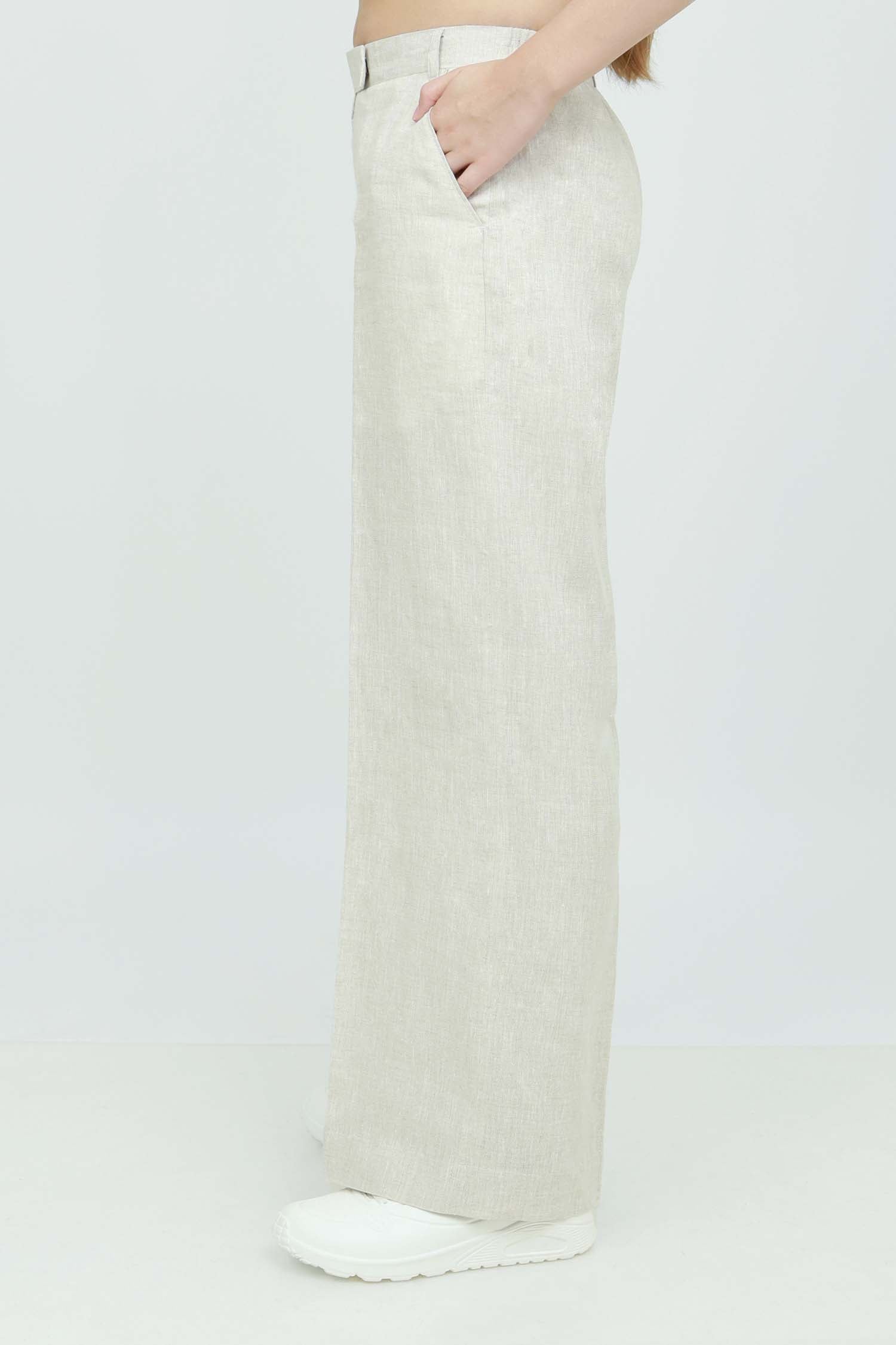 A pair of beige wide-leg trousers with a mid-rise waist, front buttons, and a relaxed fit. The trousers are fully lined and have a hook and bar closure at the waistband with an adjustable elastic belt.