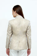 Woman wearing a beige embroidered jacket on a white background