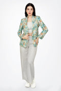 Woman wearing a patterned blazer and white pants on a white background
