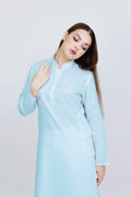 Woman wearing a light blue dress against a white background