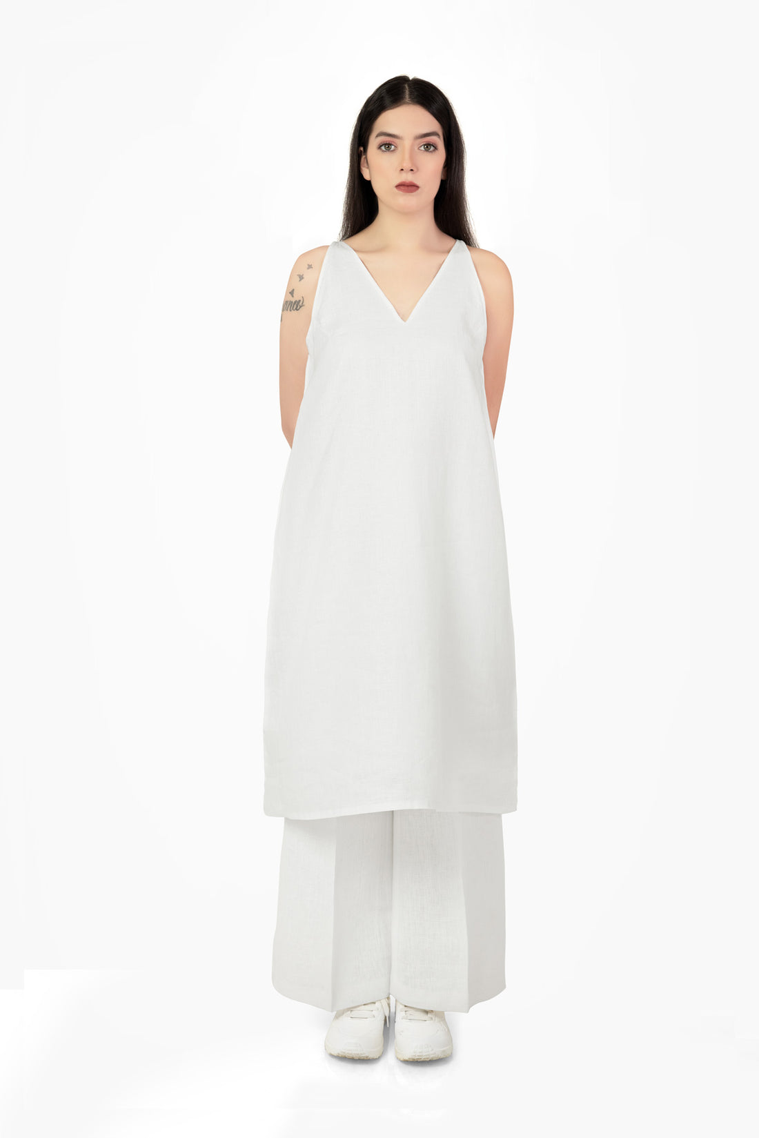 Woman wearing a white sleeveless dress on a white background