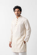 A man modeling a light beige, long-sleeved linen kurta with a mandarin collar and three-button placket, set against a plain white studio background.