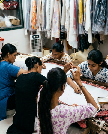 Adam Leaves artisans hand-embroidering a garment on a traditional frame