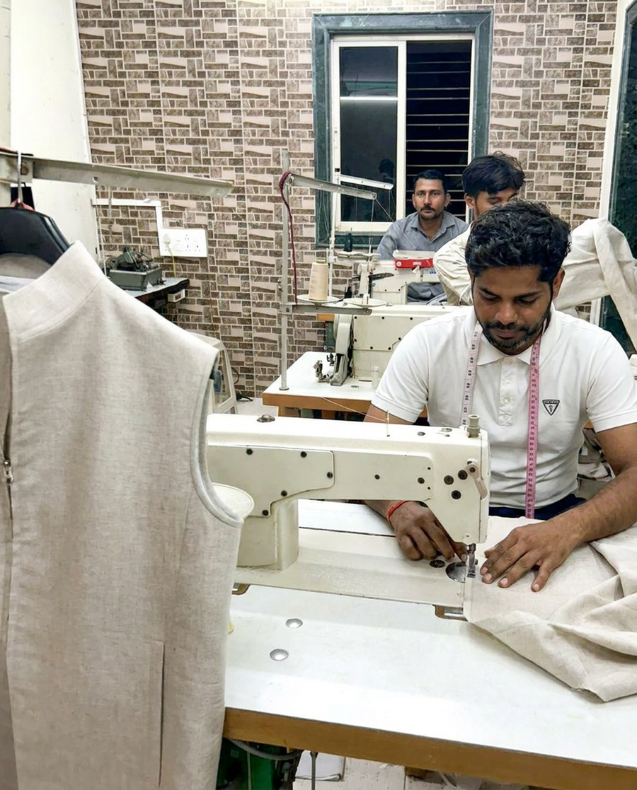 Tailor stitching a natural linen waistcoat at the Adam Leaves workshop