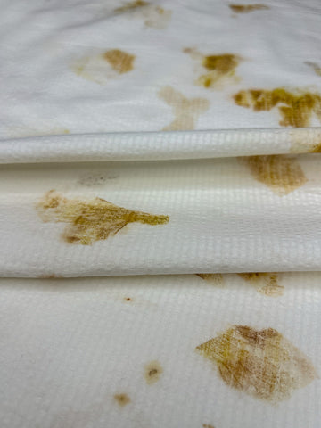 Close-up of bamboo-cotton seersucker fabric folded, hand eco-printed with onion skins