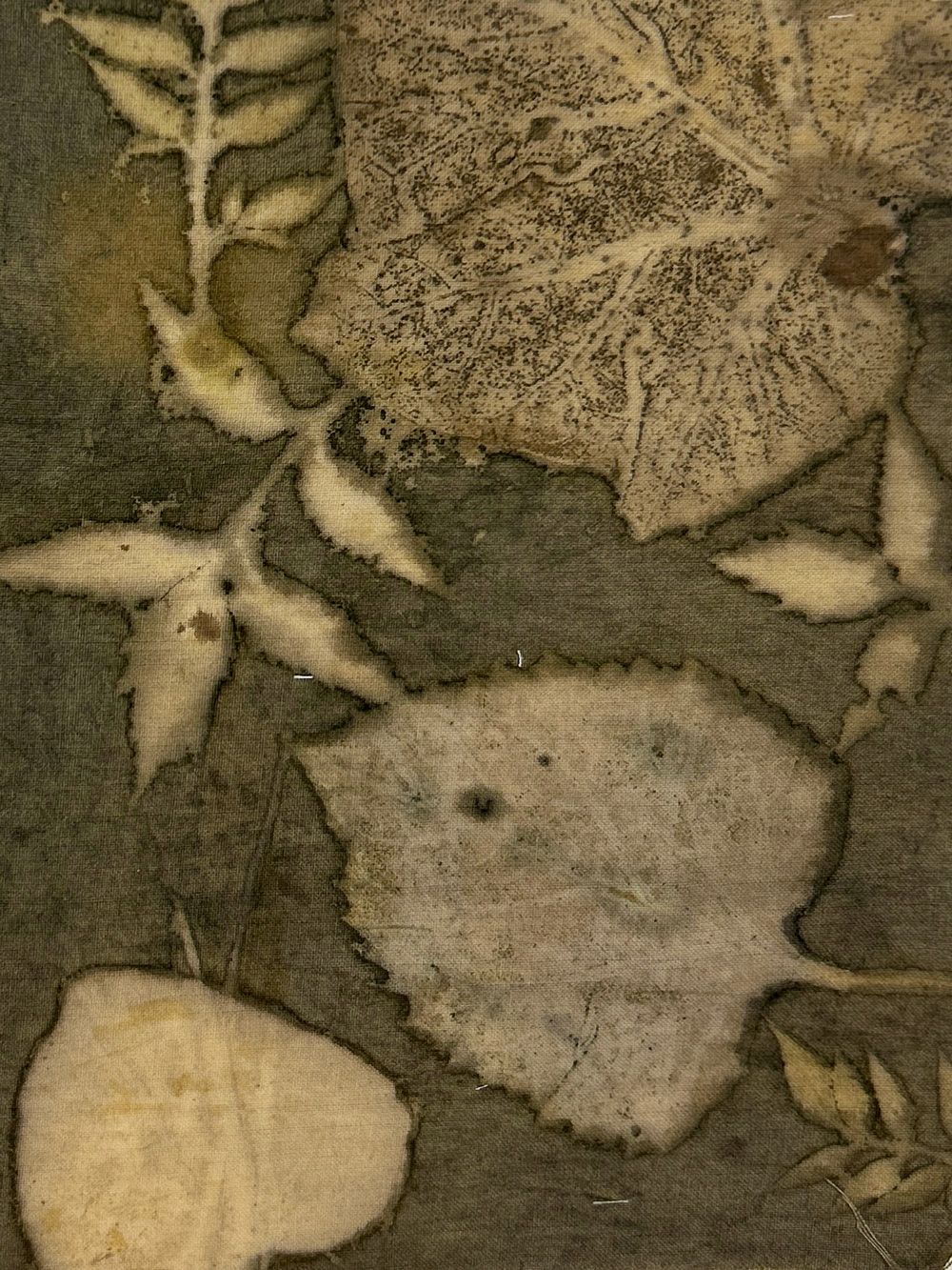 Olive hemp-cotton fabric hand eco-printed with leaves, close-up of the print