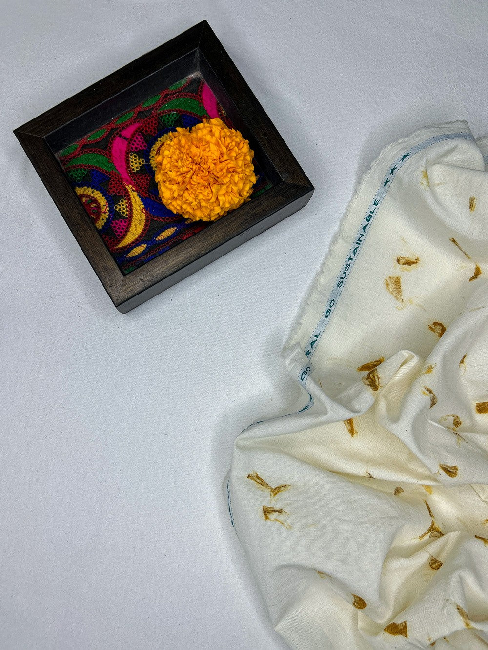 Marigold flower beside hemp-cotton fabric eco-printed with marigold petals
