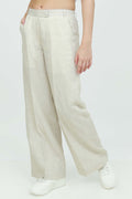 A pair of beige wide-leg trousers with a mid-rise waist, front buttons, and a relaxed fit. The trousers are fully lined and have a hook and bar closure at the waistband with an adjustable elastic belt.