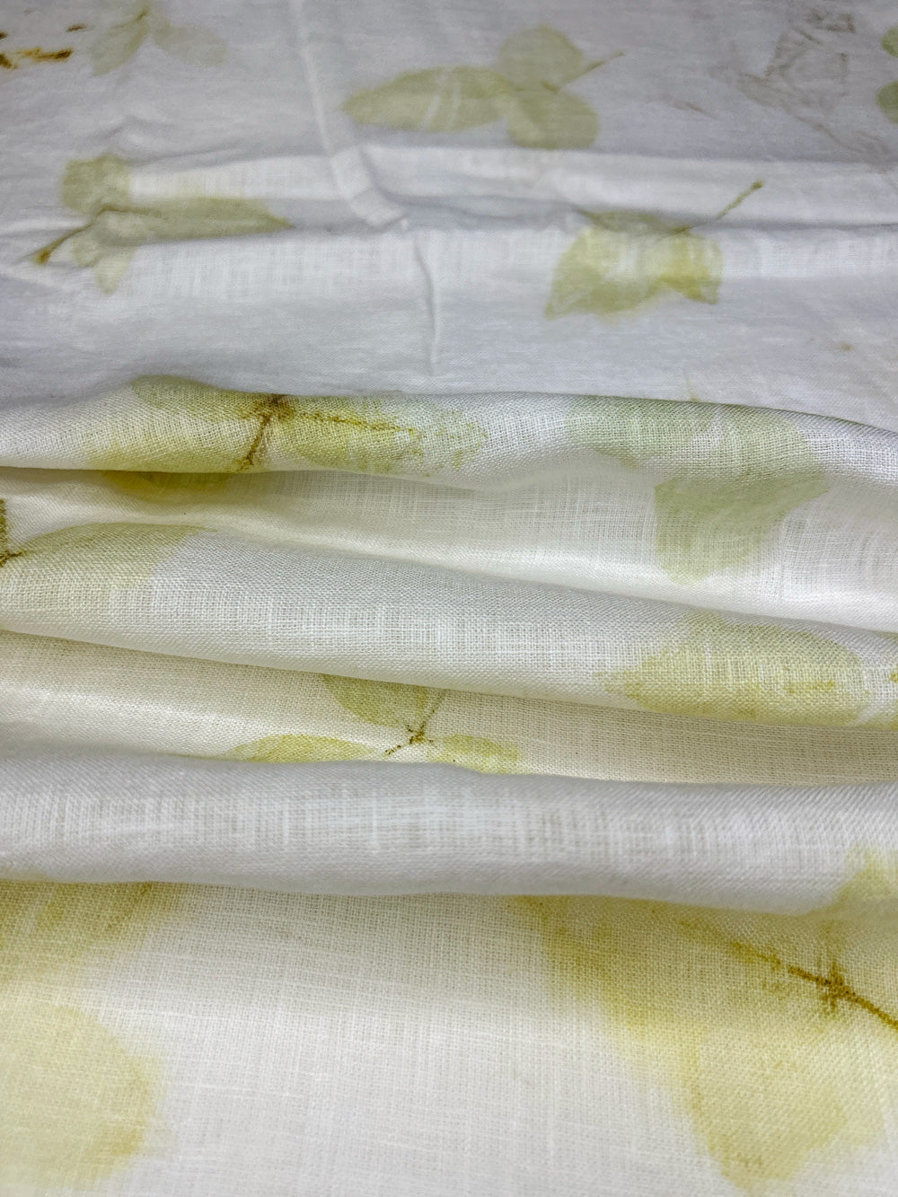 Linen fabric hand eco-printed with leaves, draped in soft folds