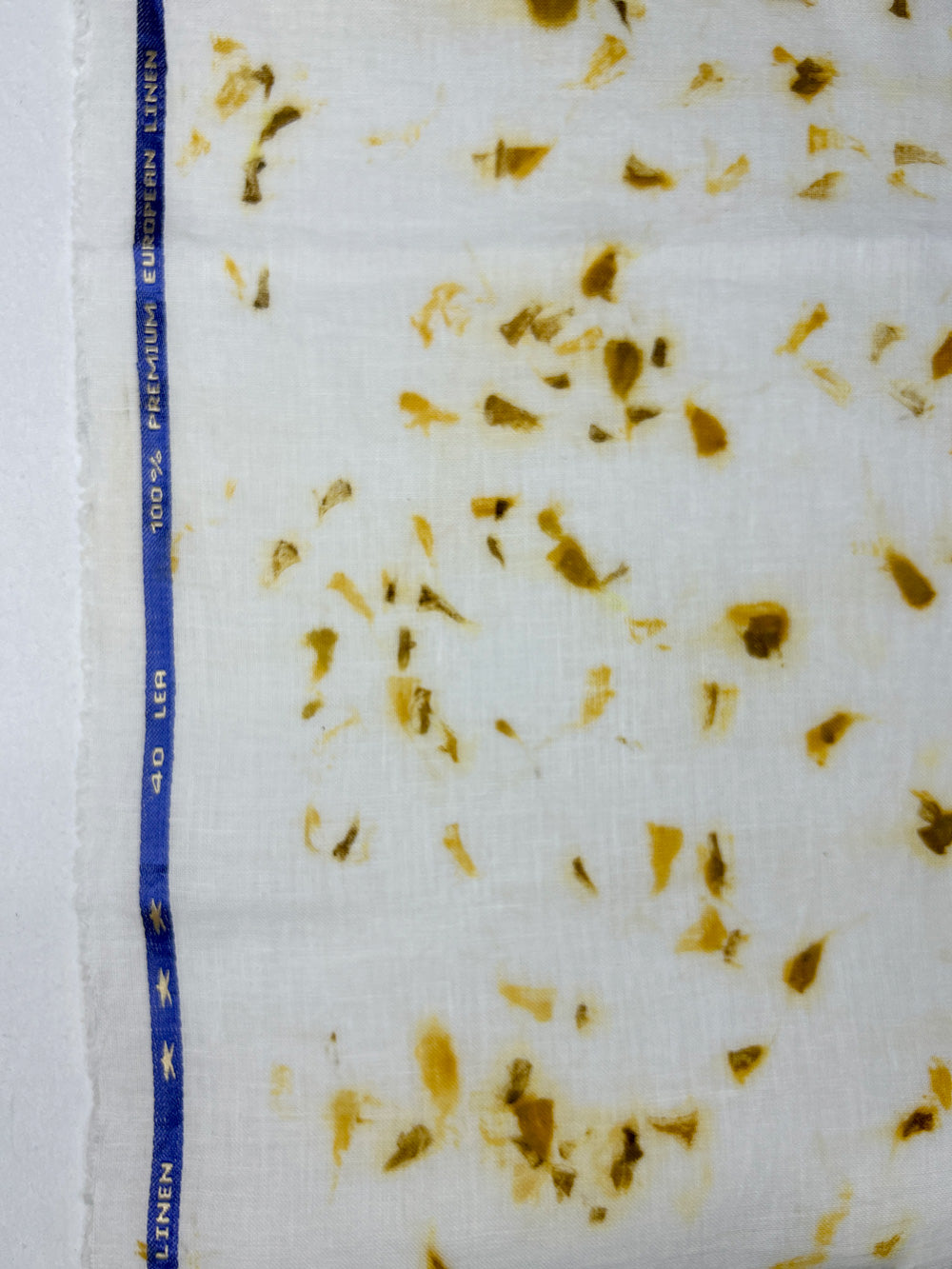 Close-up of marigold petal eco-print on linen fabric
