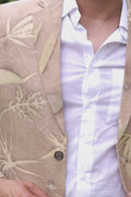A man wearing white linen trousers with a Eco_printed jacket and a white shirt.