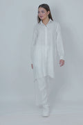 Woman wearing a long white shirt on a white background