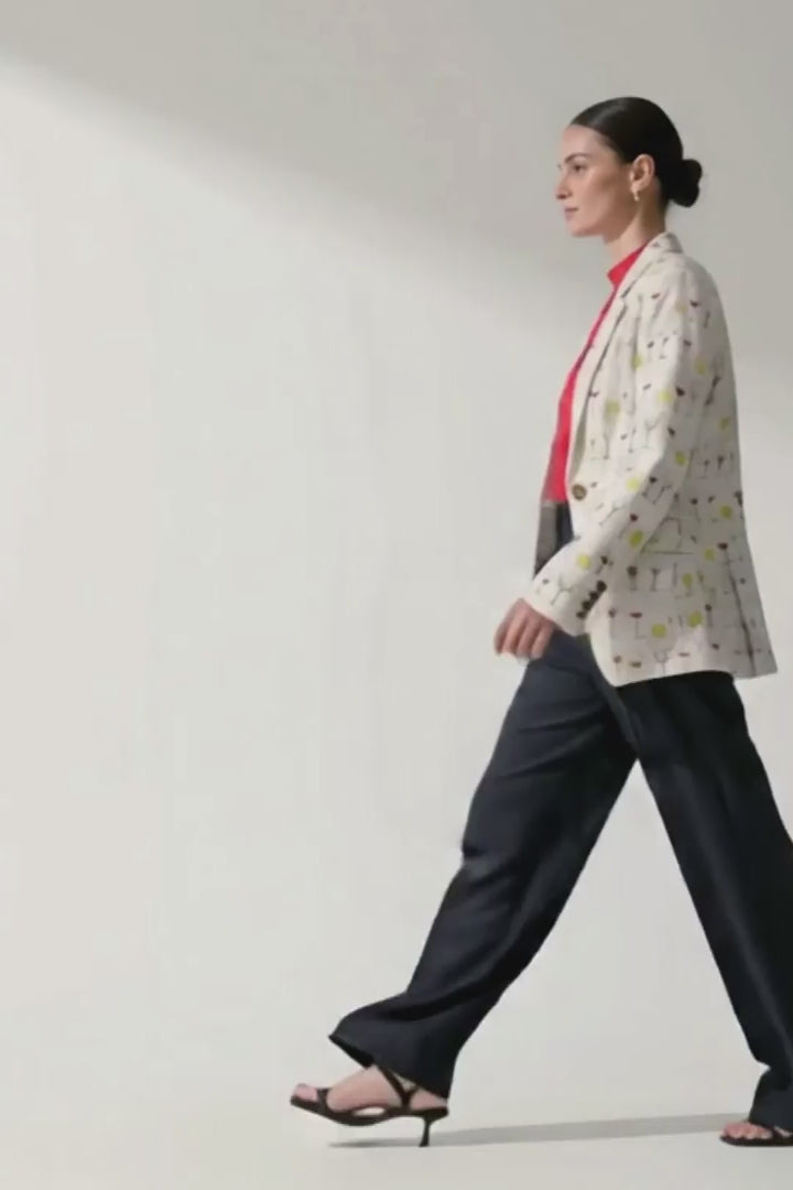 Video of a model wearing the Jam women's hemp boyfriend blazer with a red top and charcoal wide-leg trousers