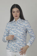 Woman wearing a blue floral Jacket over a white shirt with beige pants on a white background