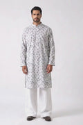 A man modeling a light gray long-sleeve hemp kurta with a silver-gray circular pattern, paired with white trousers and dark brown shoes, standing against a plain white studio background.