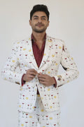 Man wearing a white suit with colorful cocktail-themed pattern on a white background