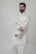 A man wearing a traditional Indian linen kurta with a mandarin collar, featuring a floral print and matching buttons, paired with light-colored trousers.