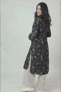 A woman standing against a white background, wearing a floral print long sleeve kurta with a mandarin collar and a V-shaped neck.