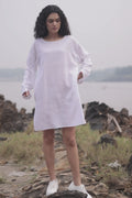 Women wearing white long top with long sleeves near beach