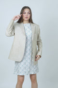 Woman wearing a sleeveless dress with a leaf pattern on a white background