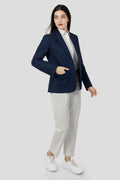 A woman modeling a blue linen blazer with a notch lapel, two-button single-breasted design, and flap pockets.